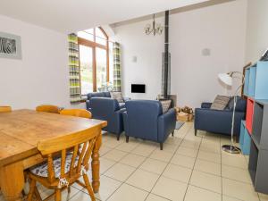 a living room with a table and blue chairs at Middlefell View Cottage in Alston