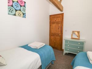 A bed or beds in a room at Middlefell View Cottage