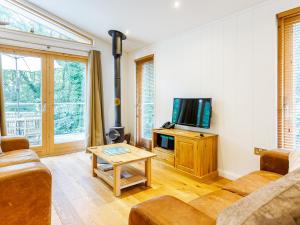 a living room with a couch and a tv at 8 Streamside in Looe