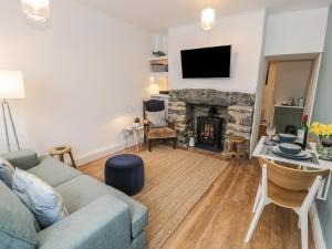 un soggiorno con divano e camino di Llys Madoc a Porthmadog