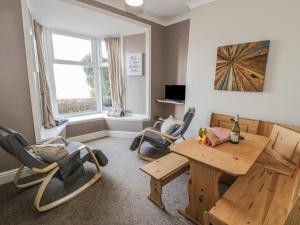a living room with a wooden table and chairs at Seaview Apartment in Barmouth