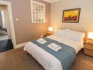 a bedroom with a bed with two towels on it at Seaview Apartment in Barmouth