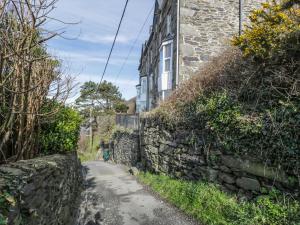 a dirt road next to a stone wall at Seaview Apartment in Barmouth