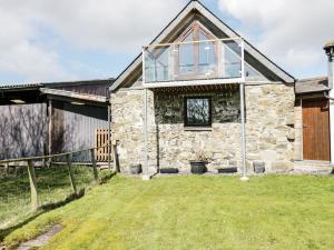 an old stone house with a glass roof at Tyddyn Isa in Denbigh