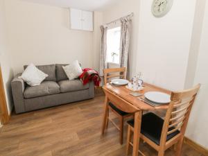 a living room with a table and a couch at Butchers Arms Cottage in Llong