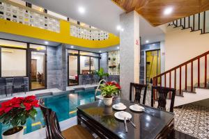 a dining room with a pool in a house at The Lit Villa Hoi An in Hoi An