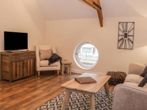 a living room with a tv and a table at The Carriage House in Shrewsbury