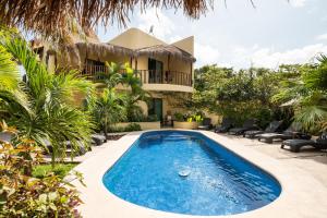 a villa with a swimming pool in front of a house at Villas Akalan in Tulum