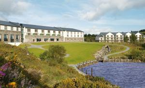 a large building with a lake in front of it at Sneem Hotel in Sneem