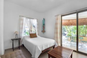 um quarto com uma cama e uma porta de vidro deslizante em Villas Akalan em Tulum