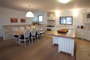 a kitchen with a table and chairs and a kitchen with white cabinets at Boutique Hotel Tamarin in Rosh Pinna