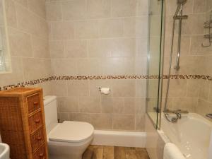 La salle de bains est pourvue de toilettes, d'une baignoire et d'une douche. dans l'établissement Fishermans Cottage, à Conwy 13 autres photos