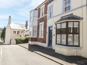 a brick house with a blue door on a street at Chwech in Menai Bridge