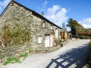 an old stone house with a stone driveway at Kestrel Cottage in Grange Over Sands