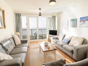 a living room with a couch and a table at 12 West End Point in Pwllheli