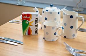 a table with two cups and a box of milk at Down Ende House Accommodation in Looe