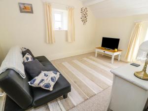 a living room with a couch and a table at Old Post Cottage in Saint Ishmaels