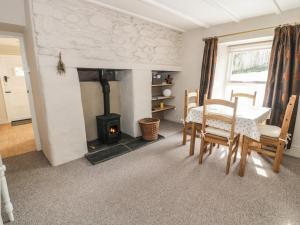 a living room with a table and a wood stove at Old Post Cottage in Saint Ishmaels