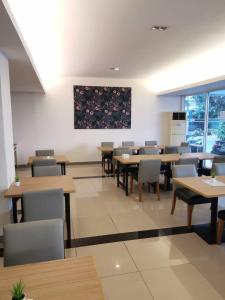 a dining room with tables and chairs and a painting on the wall at Lee Garden Bangkok in Bangkok