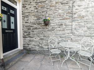 two chairs and a table in front of a brick wall at Ivy Bank in Windermere