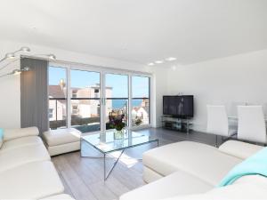 Una sala de estar con muebles blancos y una gran ventana. en An Drowes, en Newquay