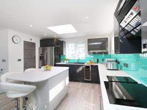 una cocina con armarios verdes y negros y una encimera blanca en An Drowes, en Newquay
