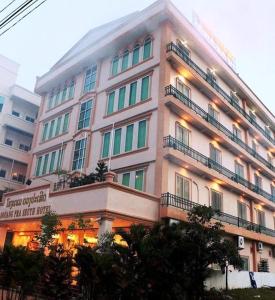 - un grand bâtiment blanc avec des fenêtres et des balcons dans l'établissement Douangpraseuth Hotel, à Vientiane