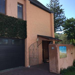 a house with a black door and a gate at Orewa Beachside in Orewa