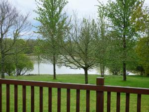 a wooden fence with a view of a lake at Chaffinch in Beaworthy