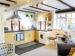 een keuken met een wasmachine en droger en een tafel bij Hele Stone Cottage in Launceston