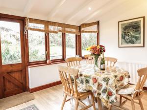 a dining room with a table and chairs and windows at Brunnion House in Hayle