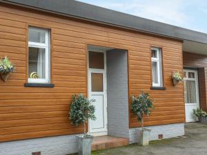 una casa de madera con dos macetas. en The Cabin en Ilfracombe