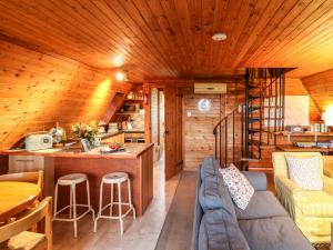 a living room with a couch and a kitchen in a log cabin at Rose Lodge in Gillingham