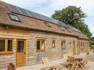 a stone cottage with solar panels on the roof at The Cow Byre, Heath Farm in Clee Saint Margaret