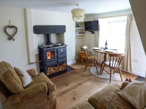 a living room with a couch and a wood stove at Fells Cottage in Sedbergh