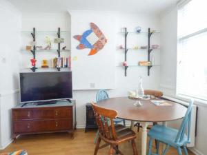a dining room with a table and a television at Tidewood in Polzeath +1 photo