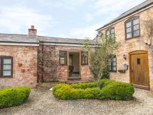 an exterior view of a brick house with a wooden door at The Old Dairy in Newnham