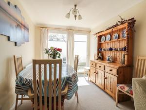 a dining room with a table and chairs and a window at 22 Trembel Road in Helston