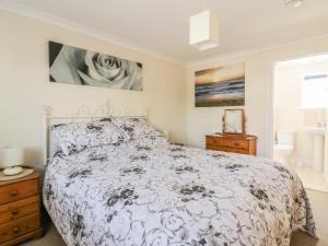 a bedroom with a large bed and a window at 22 Trembel Road in Helston