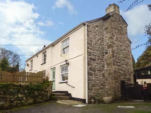 an old stone house with a stone wall at Longview Cottage in Bugle