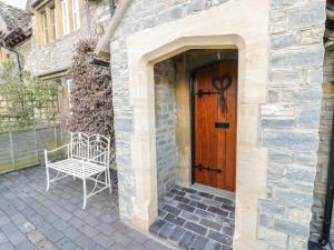 a wooden door with a bench in front of a house at Bear's Cottage in South Littleton