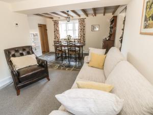 ein Wohnzimmer mit Sofa und Tisch in der Unterkunft Bear's Cottage in South Littleton + 10 Fotos