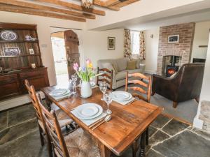 a dining room with a wooden table and chairs at Bear's Cottage in South Littleton