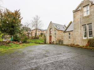 an empty driveway in front of a brick house at Allerton House Stables in Jedburgh