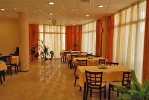 a dining room with tables and chairs in a restaurant at Hotel Venecia in Primorsko