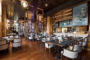 安图县长白山温泉皇冠假日度假酒店的有桌椅和酒吧的餐厅