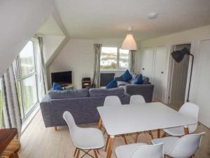 a living room with a couch and tables and chairs at Isallt Lodge in Holyhead