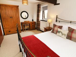 ein Schlafzimmer mit einem großen Bett mit einer roten Decke in der Unterkunft The Hayloft in Grange Over Sands