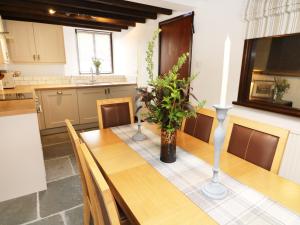 uma cozinha com uma mesa de madeira e um vaso em The Hayloft em Grange Over Sands