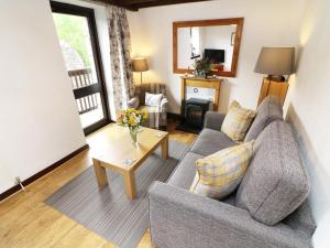 ein Wohnzimmer mit einem Sofa und einem Tisch in der Unterkunft The Hayloft in Grange Over Sands